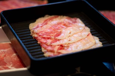 Sıcak tencere ve ızgara için siyah tepside sığır eti dilimi (barbekü veya yakiniku).