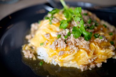 Çırpılmış yumurta kıymalı domuz eti sıcak buharda pirinç dilimlenmiş soğan ve kişniş.