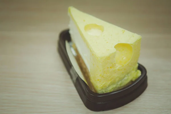 Τριγωνικό Cheesecake Συσκευασία Που Τοποθετείται Ξύλινο Τραπέζι Έτοιμο Για Κατανάλωση — Φωτογραφία Αρχείου