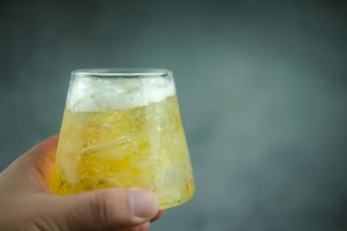 Elinde buzla bir bardak soğuk bira.