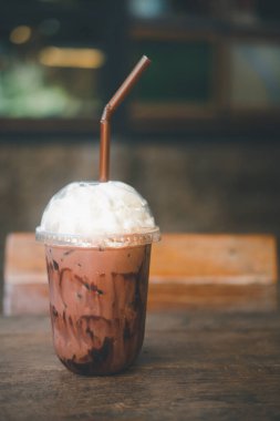 Ahşap masada krem şantili soğuk çikolata içeceği.