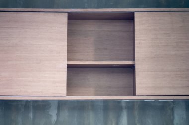 Oturma odasındaki duvarda boş ahşap bir raf var.