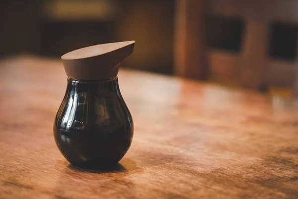 Suşi için cam şişede Shoyu sosu Tayland 'daki Japon restoranında ahşap masada duruyor.