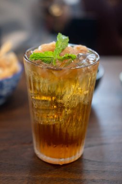 Ahşap masada taze içecek için bardakta Longan suyu.