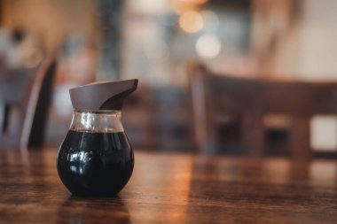 Suşi için cam şişede Shoyu sosu Tayland 'daki Japon restoranında ahşap masada duruyor.