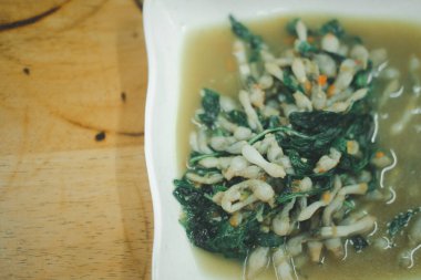 Kızarmış Jilet, acı biberli ve Tayland fesleğenli beyaz tabakta.