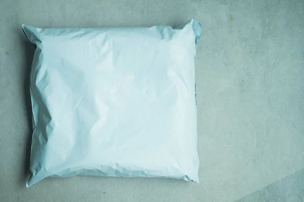コンクリート床の上のお客様に配信プラスチック製の出荷封筒 小包の配送コンセプト — ストック写真
