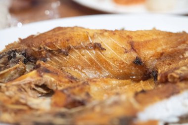 Beyaz tabakta balık soslu kızarmış balığa yakın durun.