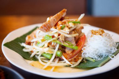 Tayland baharatlı yeşil papaya salatası ya da ızgara domuz boyunlu ve pirinç vermicelli soslu Somtum karışımı.