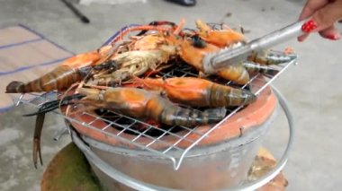 Izgara karidesleri yakın. Büyük deniz karidesleri kızgın kömürlerin üzerinde metal bir ızgarada. Asya, Tayland 'da mangal yemeği