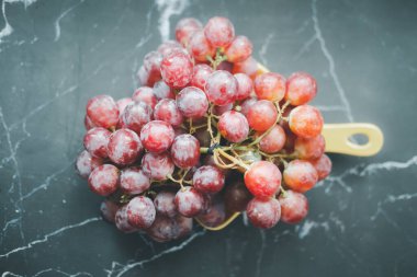 Siyah arka planda bir demet kırmızı üzüm.