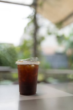 Plastik bardaktaki buzlu kahveyi ya da açık hava masasındaki buzlu Americano 'yu kapat.