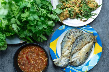 Baharatlı karides ezmesi, Nam Prik Kapi yanında kızarmış uskumru, kızarmış akasya pennata ve taze sebzeyle servis edilir. Tayland yerel popüler yemekleri