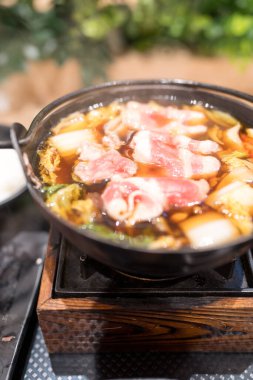 Sobalı Sukiyaki güveç tenceresi ve ocakta taze sebzeler, yemeye hazır..