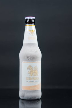 Bangkok, Tayland - 12 Eylül 2025: Buzdolabından soğuk bira şişesine yapışmış buz kristalli Singha birası şişesine yaklaş. Bu, ülkede çok popüler bir yerel bira..