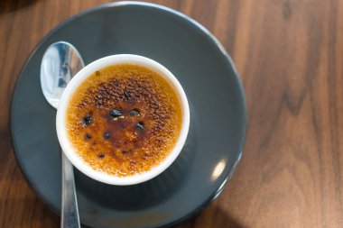 Beyaz bir ramekin içinde bir creme brulee 'nin yakın çekim görüntüsü. Üst görünüm