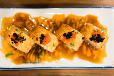 Havyarla kaplı lezzetli suşi somon ruloları. Üst görünüm