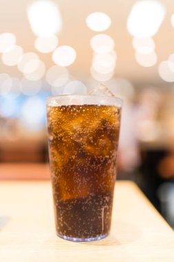 Bokeh arka planında buz küpleriyle köpüklü bir içecek.