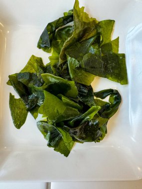 Beyaz bir tabakta alg wakame yosununun üst görüntüsü.