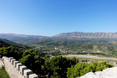Eski bir kalenin harabelerinden dağların ve Berat şehrinin manzarası