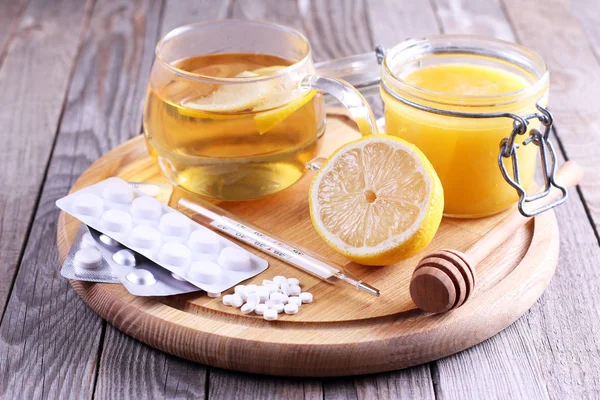 Hot tea for colds, medicine and Honey on wooden table