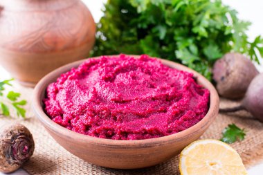 Pancar Humus, krem ve ahşap arka plan üzerinde seramik bir kase lezzetli