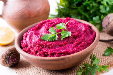 Pancar Humus, krem ve ahşap arka plan üzerinde seramik bir kase lezzetli