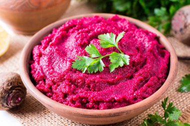 Pancar Humus, krem ve ahşap arka plan üzerinde seramik bir kase lezzetli