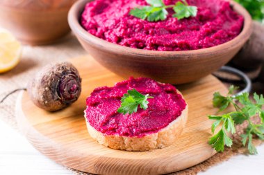 Kavrulmuş pancar humus ahşap arka plan üzerinde seramik bir kasede tost ile