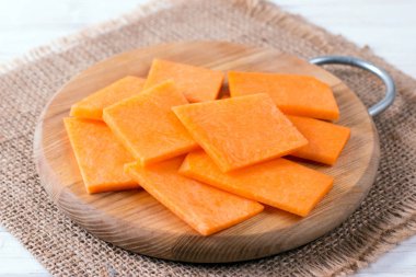 Doğranmış kabak kesme tahtası üzerinde. Dilimleri balkabağı beyaz ahşap mutfak masasında