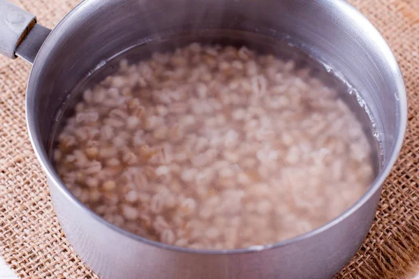 Cevada Pérola Água Uma Panela Uma Mesa Cozinha Madeira — Fotografia de Stock