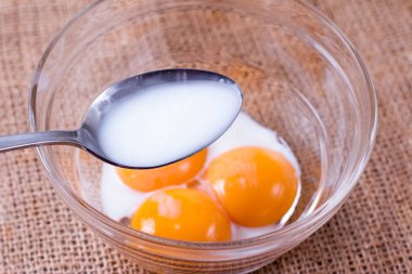 Süt yumurta sarısı cam kase içinde ekleme