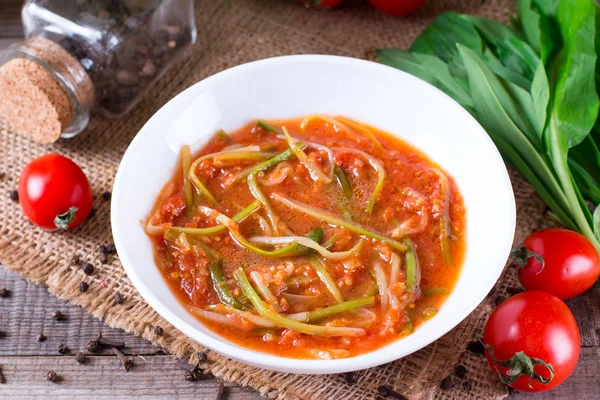 Ramson or wild garlic leaves in tomato sauce in a plate — Stock Photo, Image
