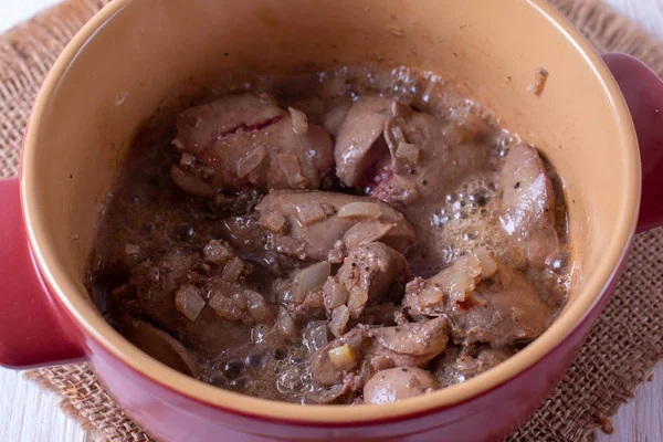 Kip lever stoofpotje met groenten in een pan op een tafel — Stockfoto