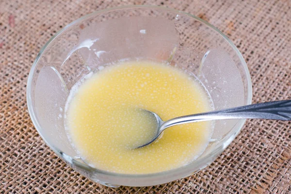 Zerlassene Butter in einer Glasschüssel auf einem Tisch — Stockfoto