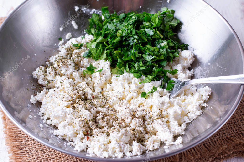 Fresh cottage cheese with herbs and spices in a metal bowl