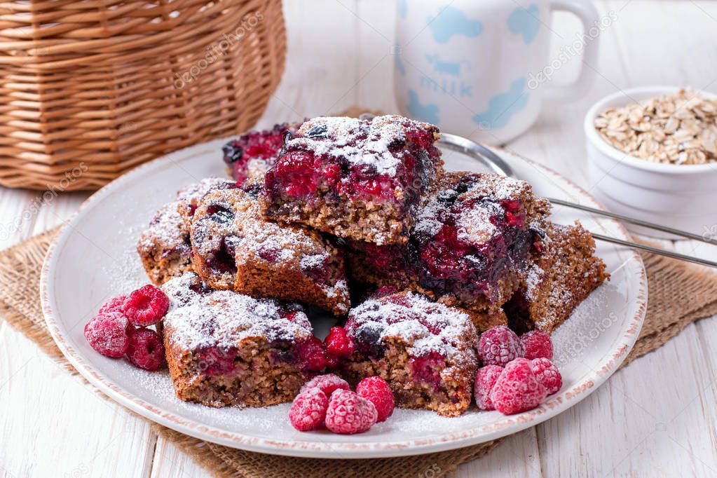 Homemade oatmeal cake with berries and powdered sugar