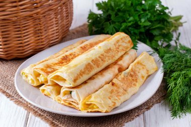 Lavaş beyaz bir tabakta peynir ile rulo