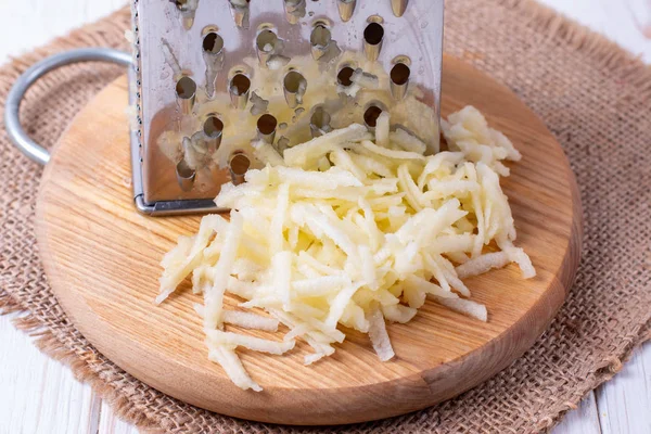 Grated apple on a cutting board on wooden table — Stock Photo, Image