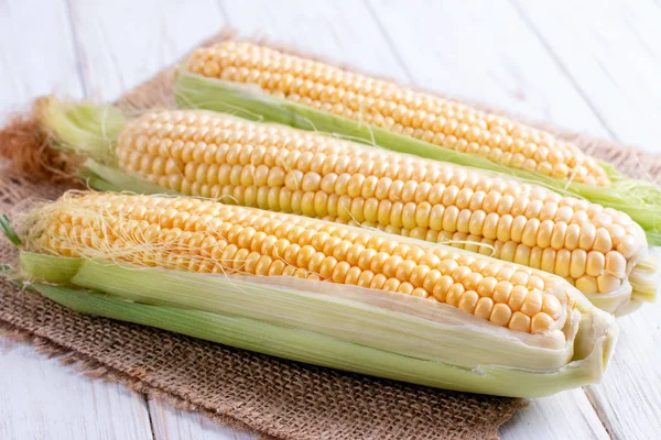 Sweet corn on a white wooden table — Stock Photo, Image