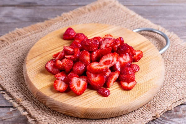 Slices of strawberries on a wooden board — Stock Photo, Image