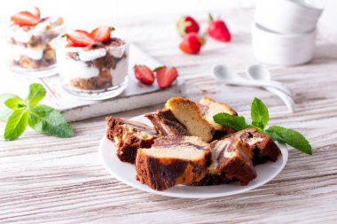 Beyaz bir tabakta mermer pasta ve beyaz tahta bir masada nane şekeri.