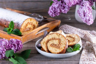 Tahta bir masada kremalı kek rulosu.