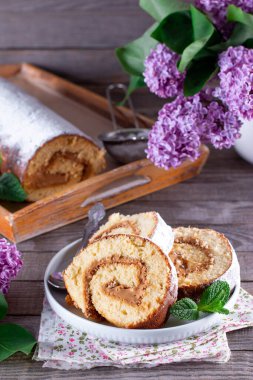 Tahta bir masada kremalı kek rulosu.