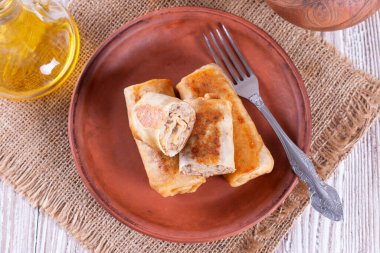 Masadaki seramik tabağa doldurulmuş krepler.