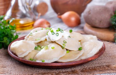 Hamur köfteleri, ahşap masada patates püresi ile dolu. Varenyky, vareniki - dolgulu börek