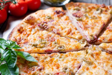 Lezzetli pizza, en iyi manzara. Domatesli İtalyan pizzası, mozarella peyniri, ahşap bir masada zeytin.