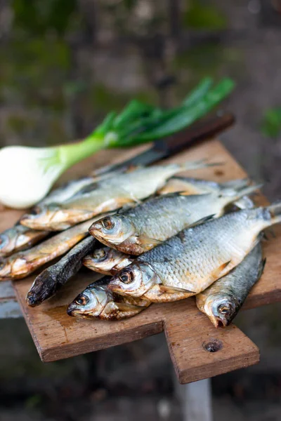 Dried salted fish on a wooden board, a great appetizer for beer on dark wooden boards