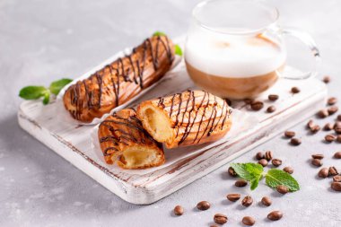 Hafif taşlı arka planda çikolatalı geleneksel Fransız ekleriydi. Geleneksel Fransız tatlısı