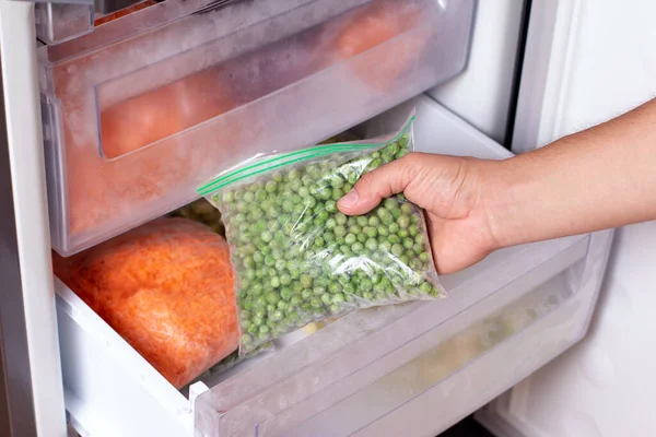 Uomo Che Prende Sacchetto Plastica Con Pisello Verde Dal Frigorifero — Foto Stock